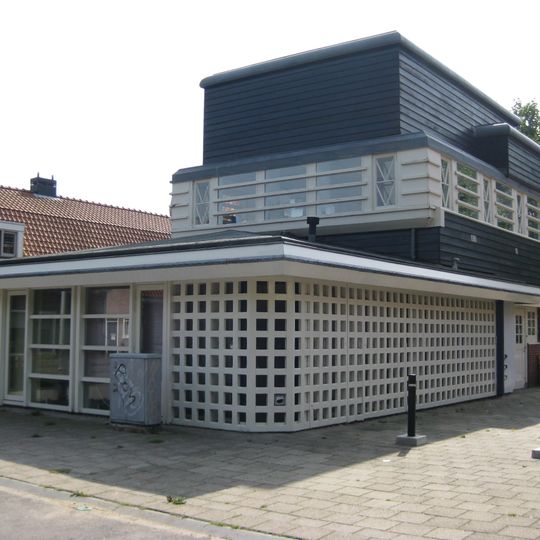 Houten gebouw, voormalige kantine en bergplaats van de afdeling Plantsoenen, bouwstijl Amsterdamse School, onderdeel van Tuindorp Oostzaan, nu tandartspraktijk