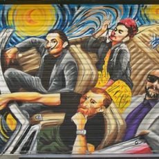 Mural representando a Frida Kahlo, Vincent van Gogh y Salvador Dalí viajando en un automóvil descapotable.
