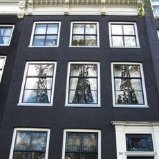 Huis met gevel onder rechte lijst met consoles, dakkapel en balustrade