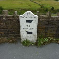 Milestone, Burnley Road; as road goes over railway, SE of bend