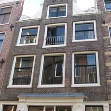 Pand met halsgevel met gedeelde vleugelstukken en palmet in de afdekking