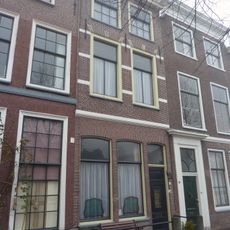 Pand met lijstgevel met speklagen. Onderbouw modern