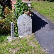 Milestone, ExYW at jct with B1392, in front of house opp. PH