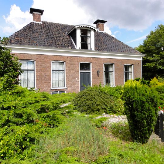 Boerderij met als dwarshuis terzijde voor de schuur gebouwd voorhuis met sierlijst, dakkapel en hoekschoorstenen met borden