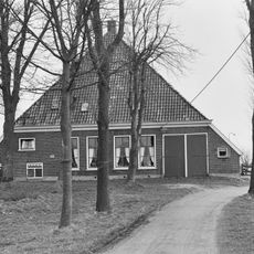 Stelphoeve met vier woonhuisvensters in de voorgevel waarnaast links de kelder met opkamer rechts van de inrit