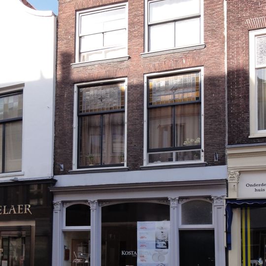 Pand met lijstgevel voor huis van parterre en twee verdiepingen. Geprofileerde, hardstenen vensterdorpels, drie consoles onder de lijst. Ramen en pui modern