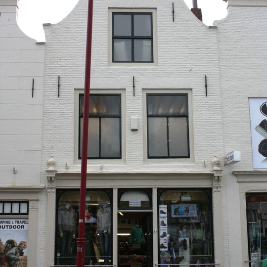 Huis met geverfde lijstgevel, aan de hoeken ingezwenkt