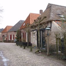 Hoeve onder rieten dak met mooie houten deeldeur