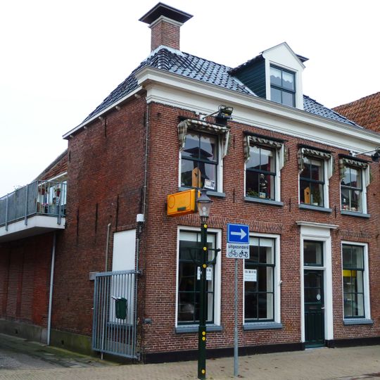 Pand met verdieping en voorbouw met forse kroonlijst onder dwars schilddak