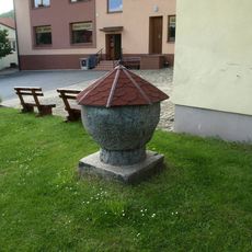 Kamenná křtitelnice u kostela svatého Mikuláše v Heřmanově