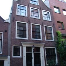 In Huis met latere gevel onder klokvormige top met houten fronton