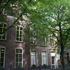 Klooster, gebouwd op een, ten opzichte van de rooilijn dwarsgeplaatste, asymmetrische T-vormige plattegrond en in baksteen opgetrokken onder samengesteld zadeldak gedekt met leien in Maasdekking