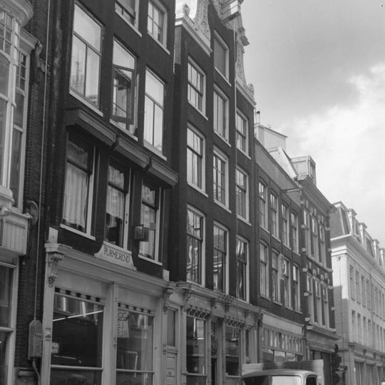 Pand met gevel onder rijk gebeeldhouwde brede hals van bijzonder ontwerp