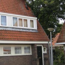 Blok met 2 keukenwoningen, zo genoemd vanwege destijds nieuwe plaatsing van keuken aan de voorzijde, aan de zijkant een houten topgevel, bouwstijl Amsterdamse School.