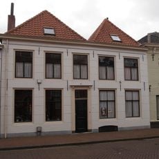 Vijf traveeën breed pand met gepleisterde lijstgevel