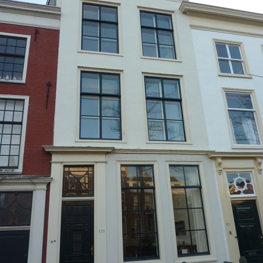 Pand met gepleisterde gevel met rechte kroonlijst. Stoep en stoeppalen.