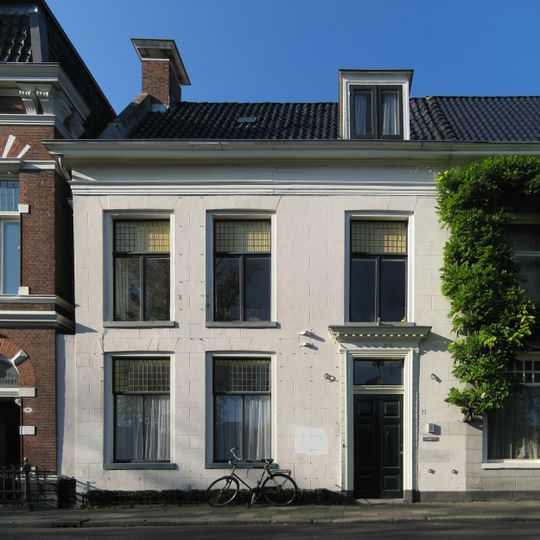 Wit gepleisterd pand met dwarsvleugel