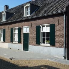 Pand zonder verdieping onder een doorlopend zadeldak met de nrs 6 en 8