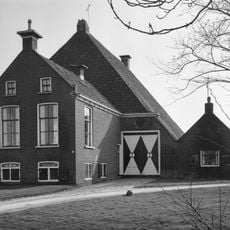 Kop-rompboerderij met onderkelderd voorhuis met zesruitsvensters en twee schoorstenen