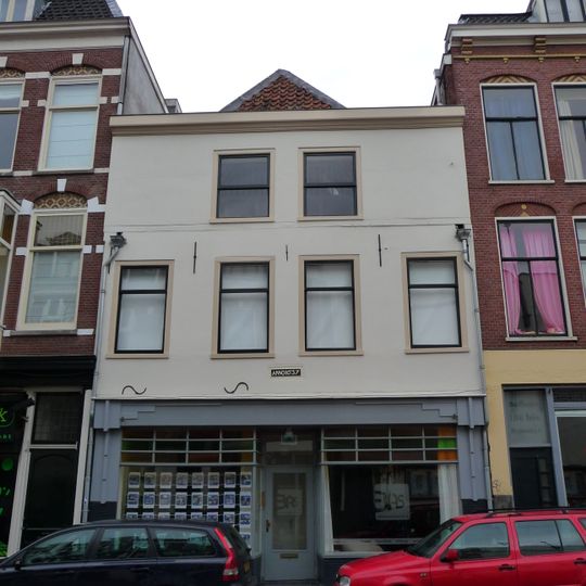 Huis met twee bouwlagen, een kap loodrecht op de straat en een kelder onder het achterste deel