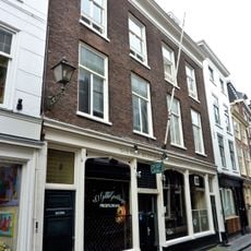 In oorsprong twee panden, samengetrokken achter een lijstgevel ter breedte van vier vensterassen