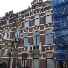 Pand in neo-renaissance trant met trapgevel boven de middenas. De gevel is versierd met geblokte ontlastingsbogen en banden