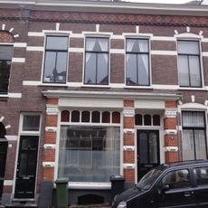 Woonblokje, bestaande uit één benedenwoning met winkel en twee bovenwoningen
