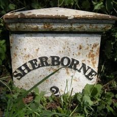 Milepost, top of Charlock hill on rough verge. 50M N of bridleway/track crossing road.