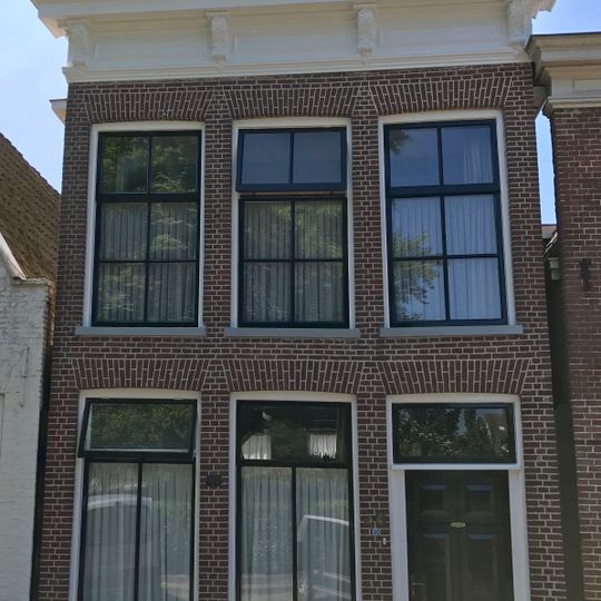 Pand met verdieping en rechte kroonlijst met gesneden consoles onder voor afgeschuind zadeldak met topschoorsteen