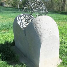 Plastika z kamene a kovu u cesty západně od Mělnického Vtelna