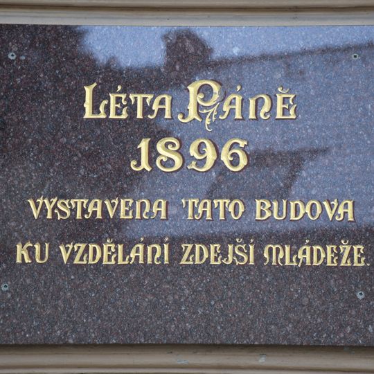 Deska na budově školy v Pohankově ulici