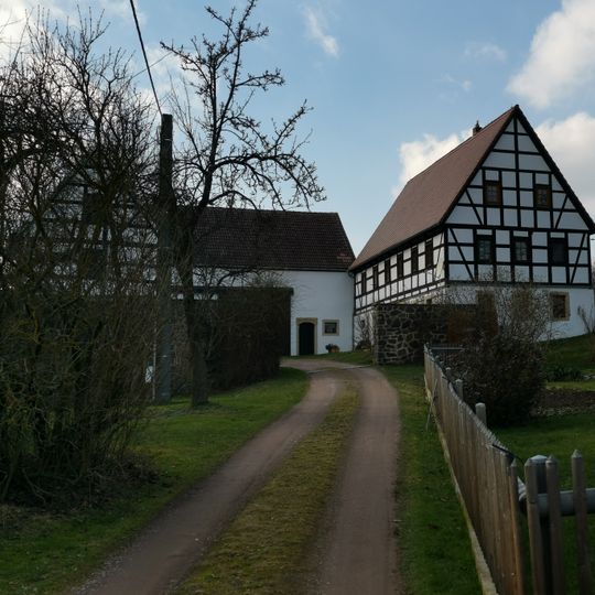 Wohnstallhaus, Seitengebäude, Scheune und Hofmauer eines Dreiseithofes Am Anger 4