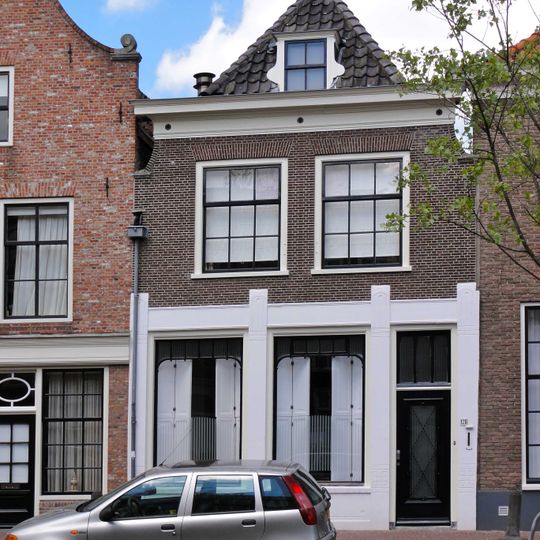 Pand met ingezwenkte gevel met lijst en in de verdieping schuiframen