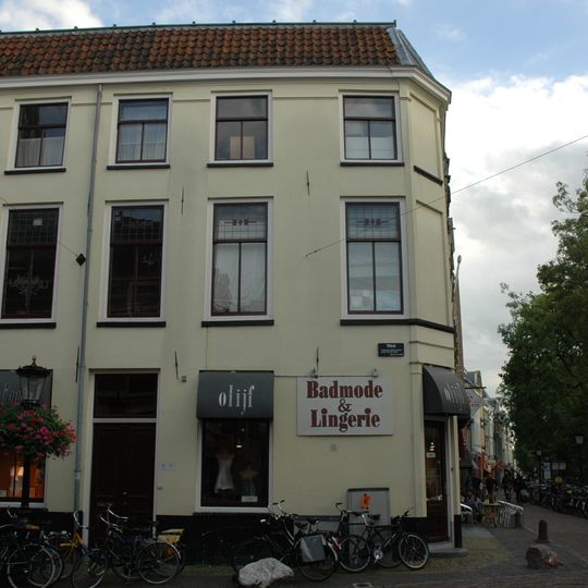 Pand bestaande uit twee bouwlagen, een kap met de nok loodrecht op de straat en een kelder onder een deel van het huis