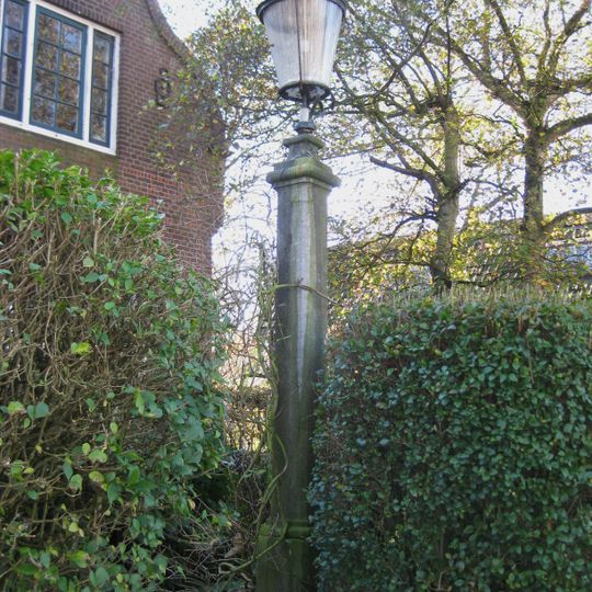 In de tuin een hardstenen lantaarnpaal