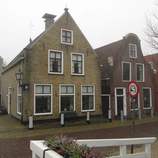 Pandje onder zadeldak tegen klokgevel met aanzetkrullen en gebogen lijst Anno 1786