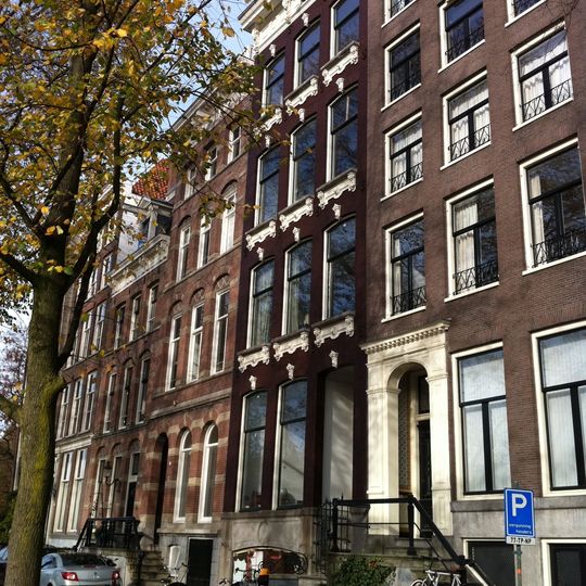 Huis met gevel onder rechte lijst met consoles, voorzien van versieringen boven en onder de vensters.