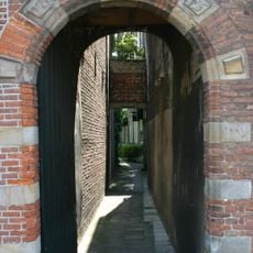 Geprofileerd rondboogpoortje. Sluitsteen met reliëf van een paard. Gerestaureerd 1949