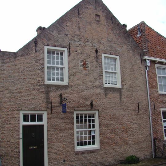 Huis met schilddak tegen zij-topgevel en met gepleisterde lijstgevel