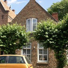 Huis onder zadeldak en met aan voor- en achterzijde een topgevel