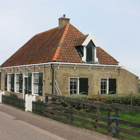 Woning onder tentdak. Vensters met roeden en luiken