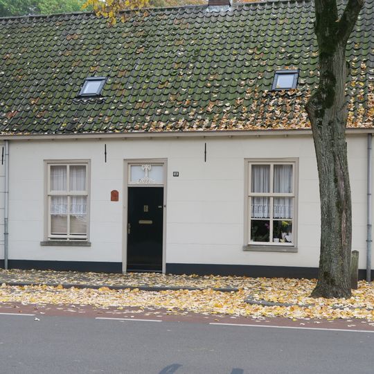 Wevershuisje bestaande uit begane-grond met pannen zadeldak, dat rechts aansluit tegen een puntgevel met rollaag en links doorloopt over nr 56. Gepleisterde voorgevel