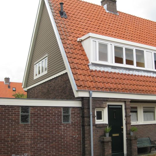 Blok met 8 keukenwoningen, zo genoemd vanwege destijds nieuwe plaatsing van keuken aan de voorzijde, aan de zijkant een houten topgevel, bouwstijl Amsterdamse School.