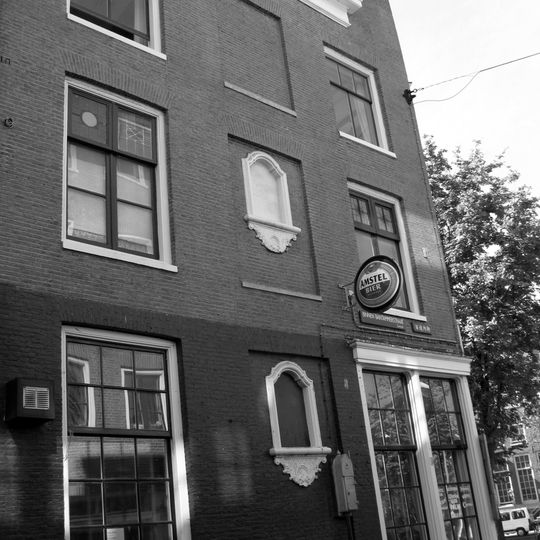 Hoekhuis met klokgevel en gebeeldhouwde trapvensters