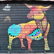 Mural representando un toro estilizado, pintado con colores brillantes sobre fondo negro. El diseño del interior del cuerpo del toro es abstracto y tiene elementos decorativos y ornamentales.