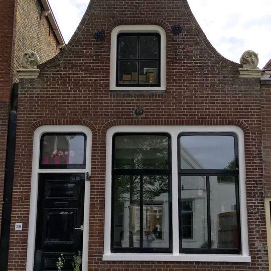 Pand met zeer eenvoudige herbouwde klokgevel met aanzetkrullen