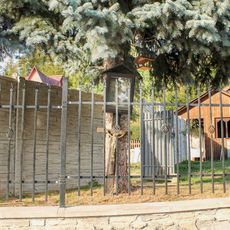 Obrázek a dřevěný kříž v Hrabenově v zahradě za plotem