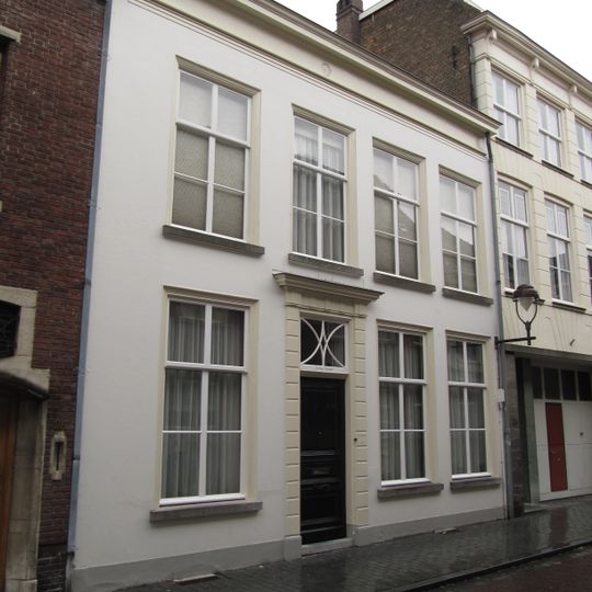 Huis met witgepleisterde lijstgevel en ingangspartij met geblokte pilasters en kroonlijstje met triglyphen
