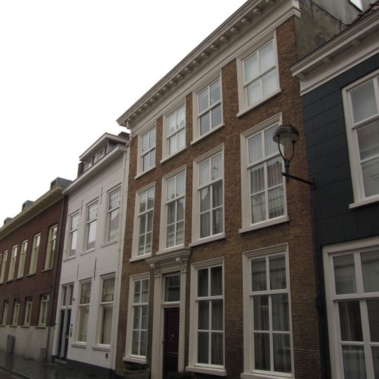 Huis met ontpleisterde lijstgevel, en met pilasters en kroonlijst versierde ingang