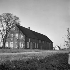 Boerderij van het dwarsdeeltype, bakstenen woonhuis en houten bedrijfsgedeelte onder rieten zadeldak